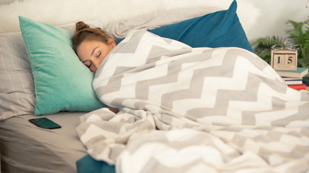 Woman sleeping tucked in a warm blanket